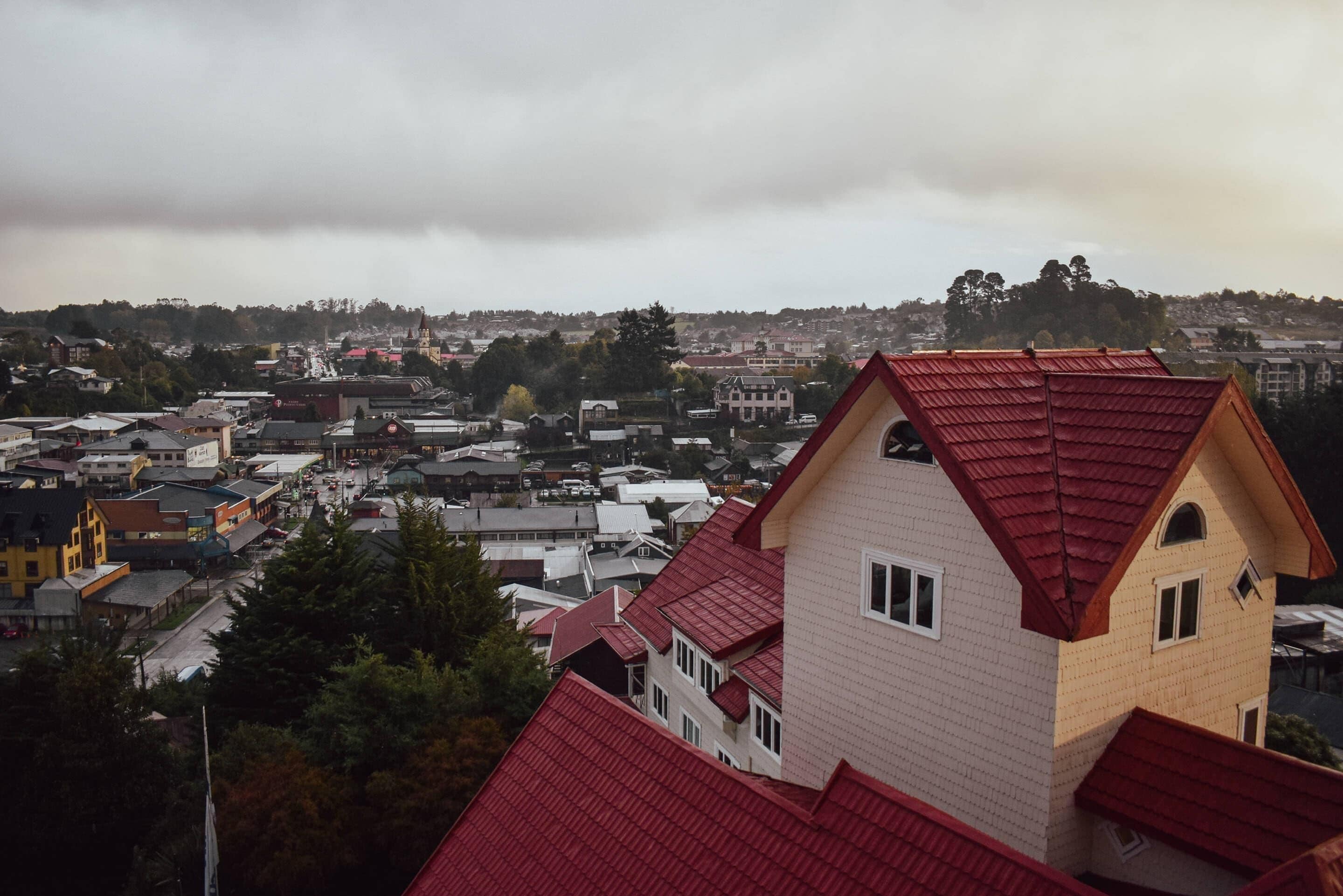 Un pueblo con un edificio destacado de techo rojo y fachada blanca.
