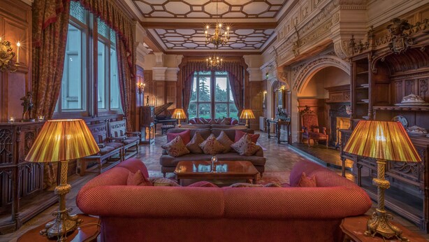A grand room with a large sofa set, ornate chandeliers, and a piano. - Lough Rynn Castle (Mohill)