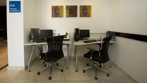 A workspace with two desks, each with a computer and a chair. There are three artworks on the wall. - One Aguascalientes Sur (Aguascalientes)