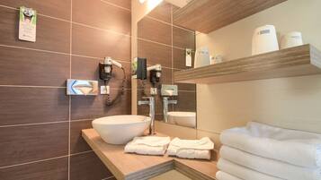 A modern bathroom with a large sink, towel rack, and a mirror.
