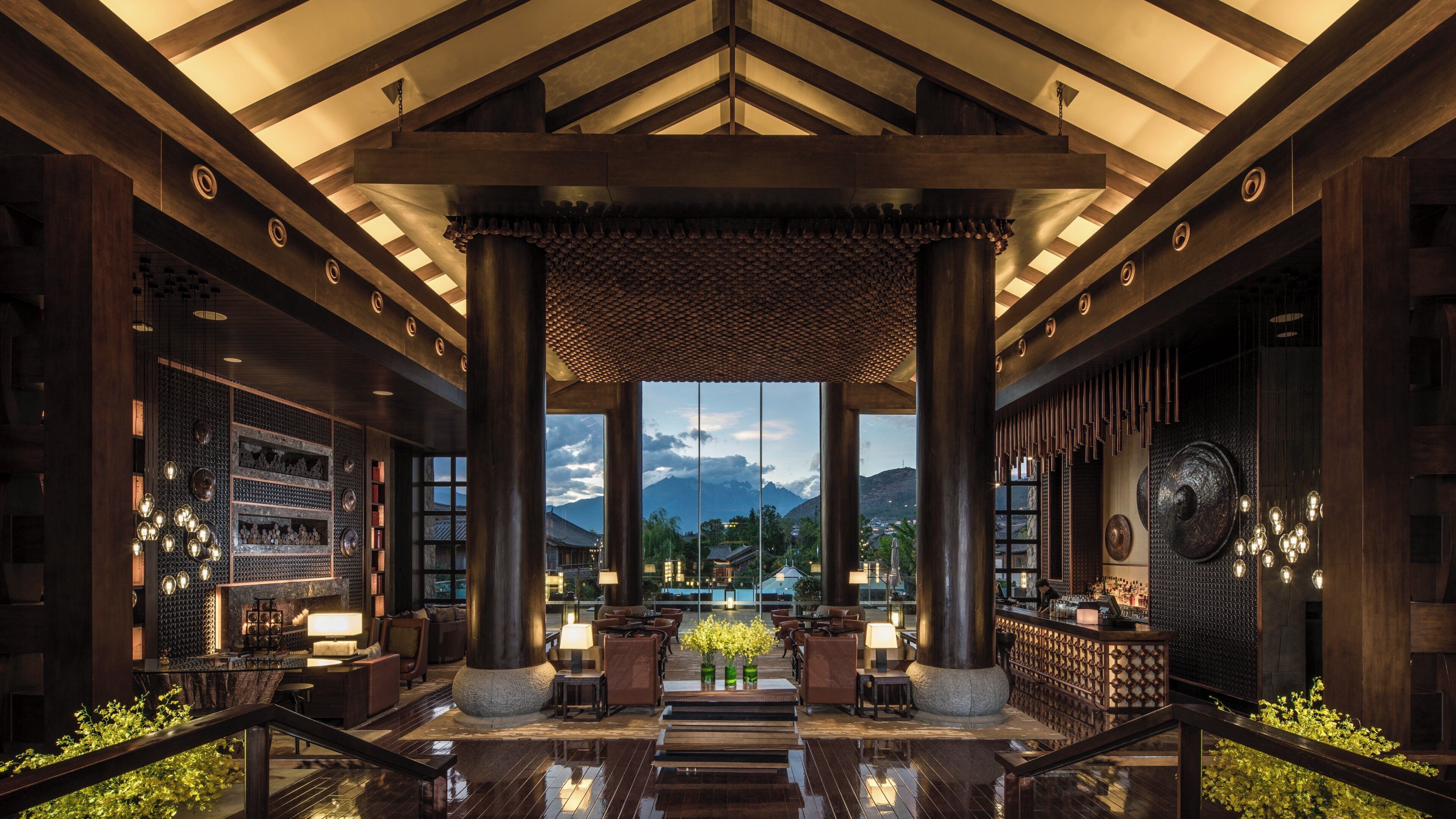 A spacious lobby with a high ceiling, large pillars, and a view of mountains.