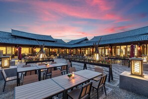 A traditional-style restaurant with wooden tables and chairs, outdoor seating, and lanterns. - InterContinental Lijiang Ancient Town Resort by IHG (Lijiang)