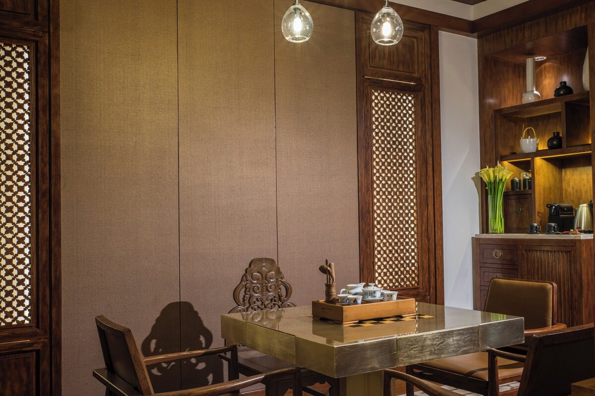 A traditional dining room with a wooden table, chairs, and a decorative cabinet.