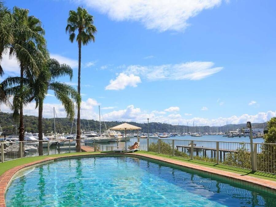 A swimming pool with a view of a marina and boats.