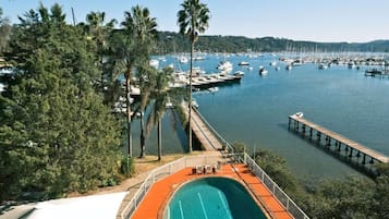 A marina with boats docked, a swimming pool, and a wooden pier.