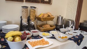 A breakfast buffet with various food items and beverages. - Hotel La Casona (Cuenca)