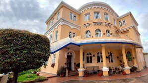 A large, multi-story building with a curved balcony, columns, and a covered entrance area. - Hotel La Casona (Cuenca)