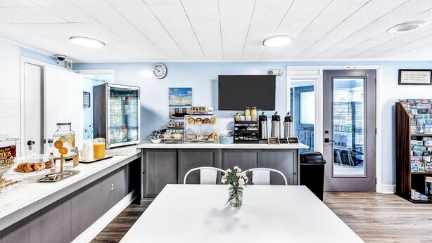 Une cuisine moderne avec un plan de travail blanc, une grande fenêtre et une vue sur la ville.
