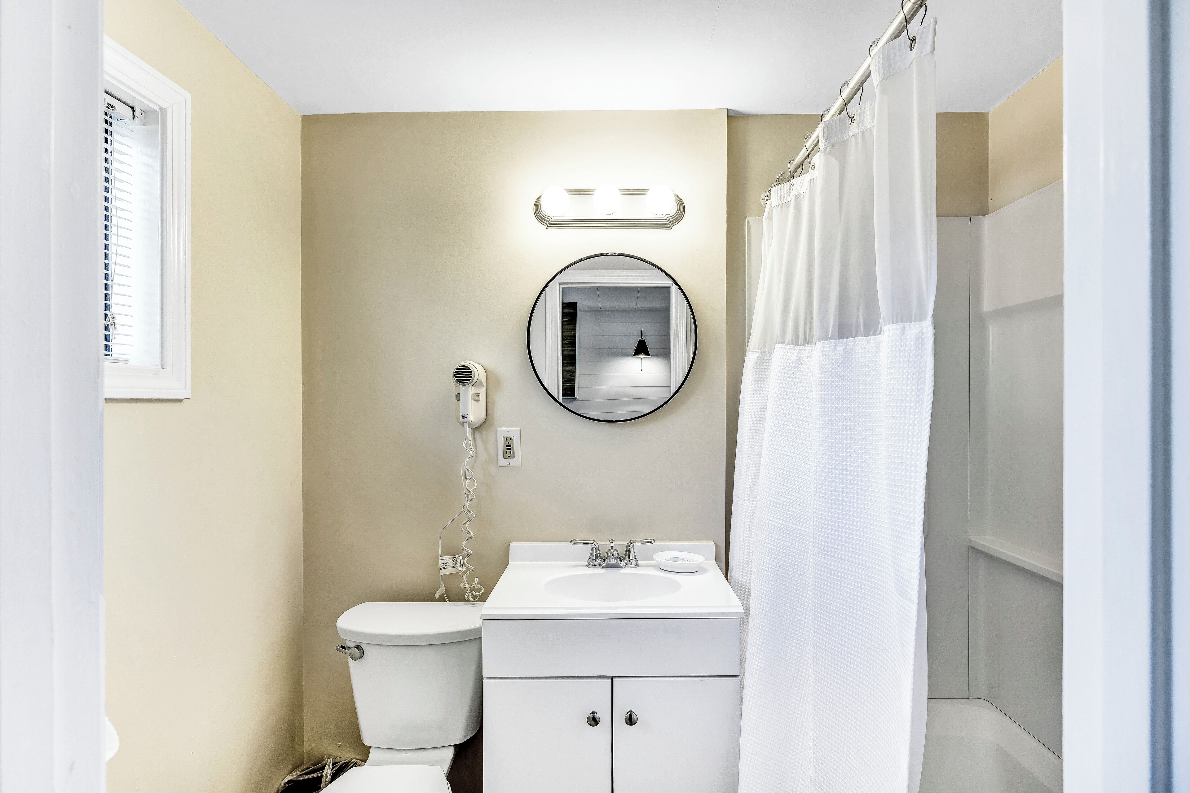 Un baño con inodoro, lavabo y espejo.