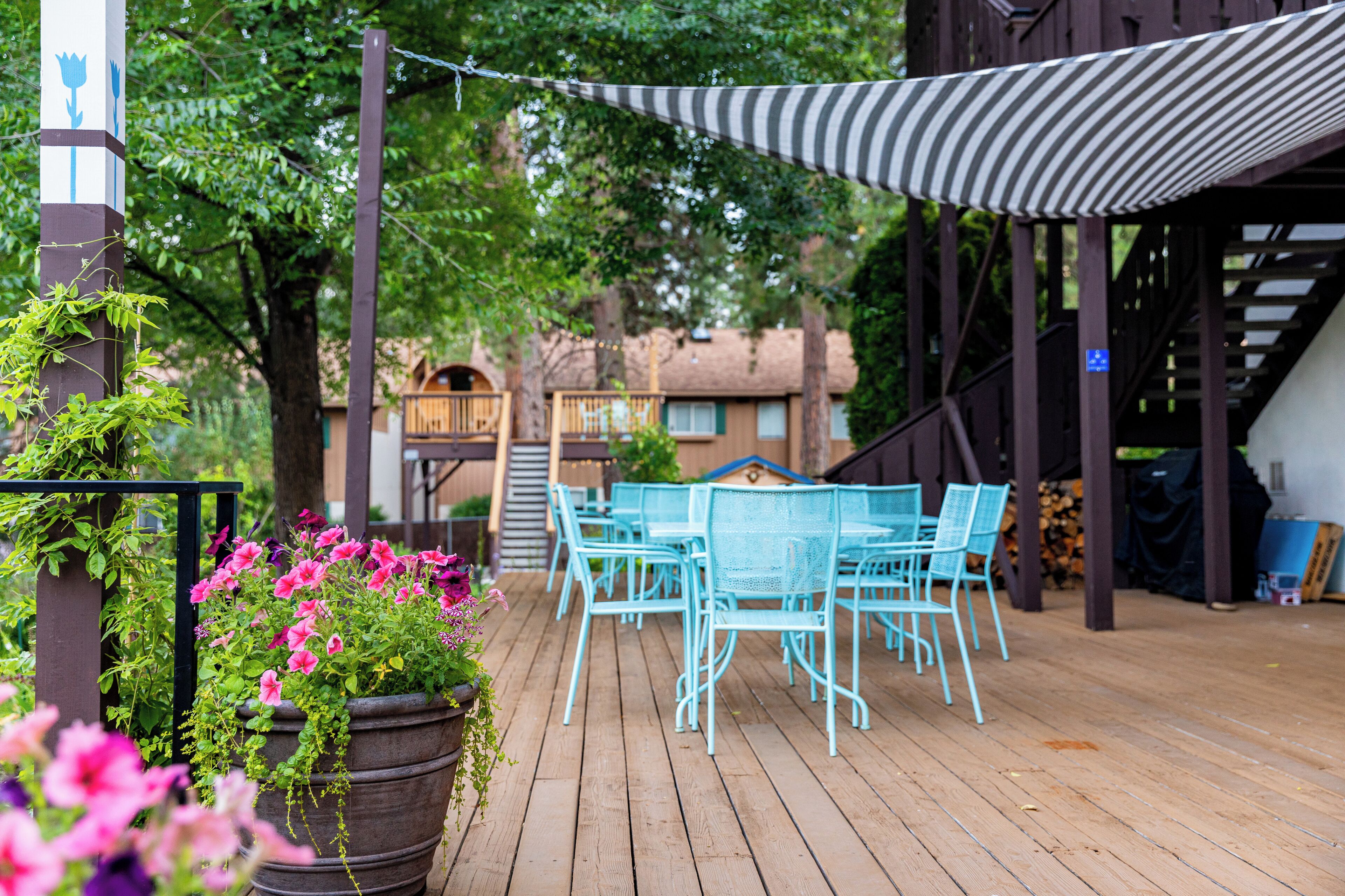 A wooden deck with outdoor seating and a striped awning.