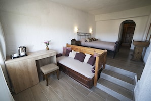 A compact room with a wooden bed, a small desk with a chair, and a bench. - Elpida Village (Agios Nikolaos)