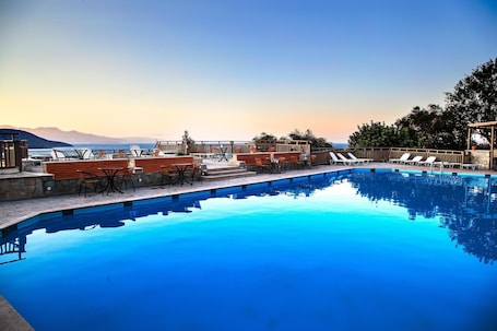 Outdoor pool, pool umbrellas, sun loungers. Elpida Village