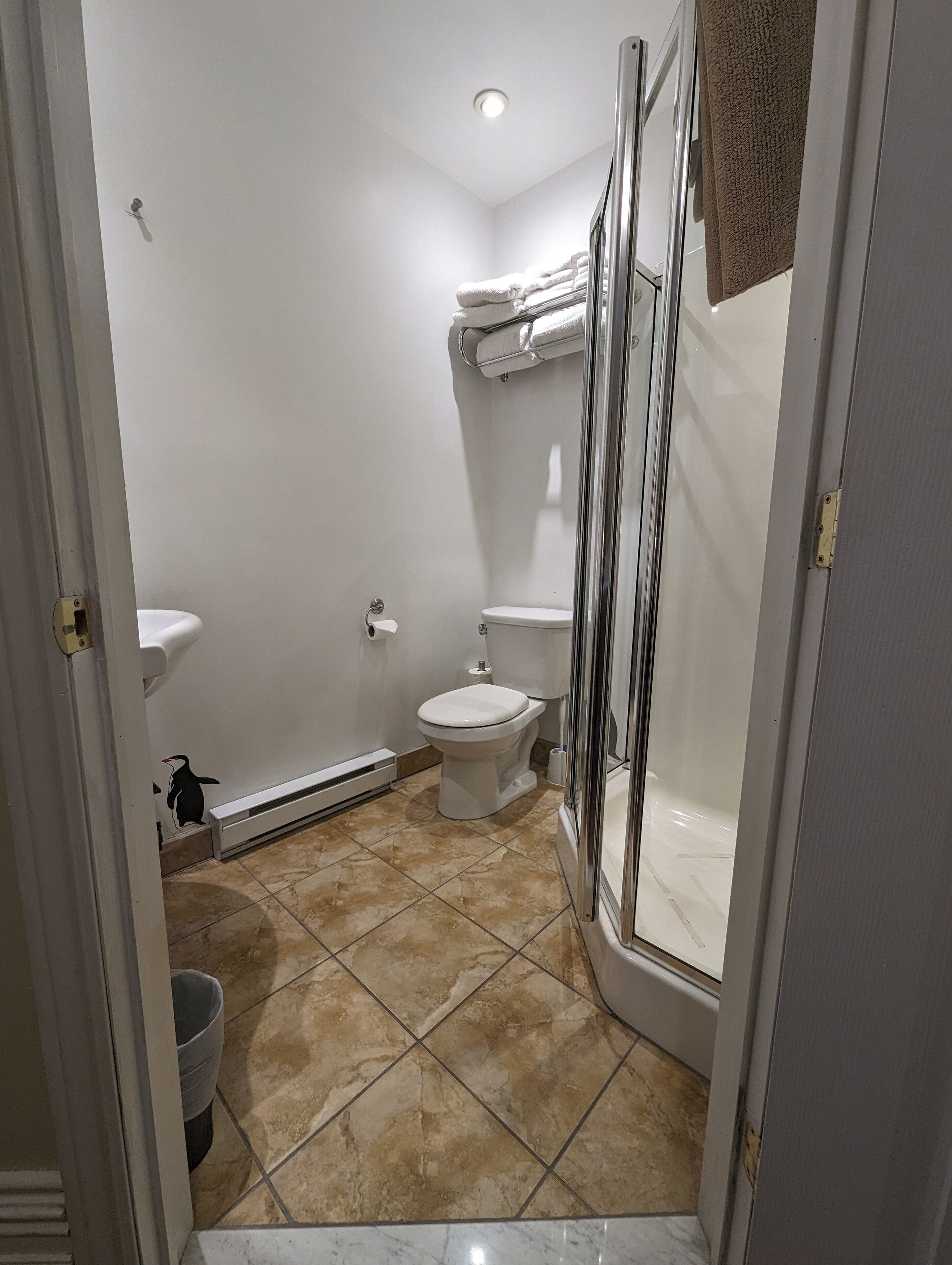 Une salle de bain avec des toilettes, un lavabo et une douche.