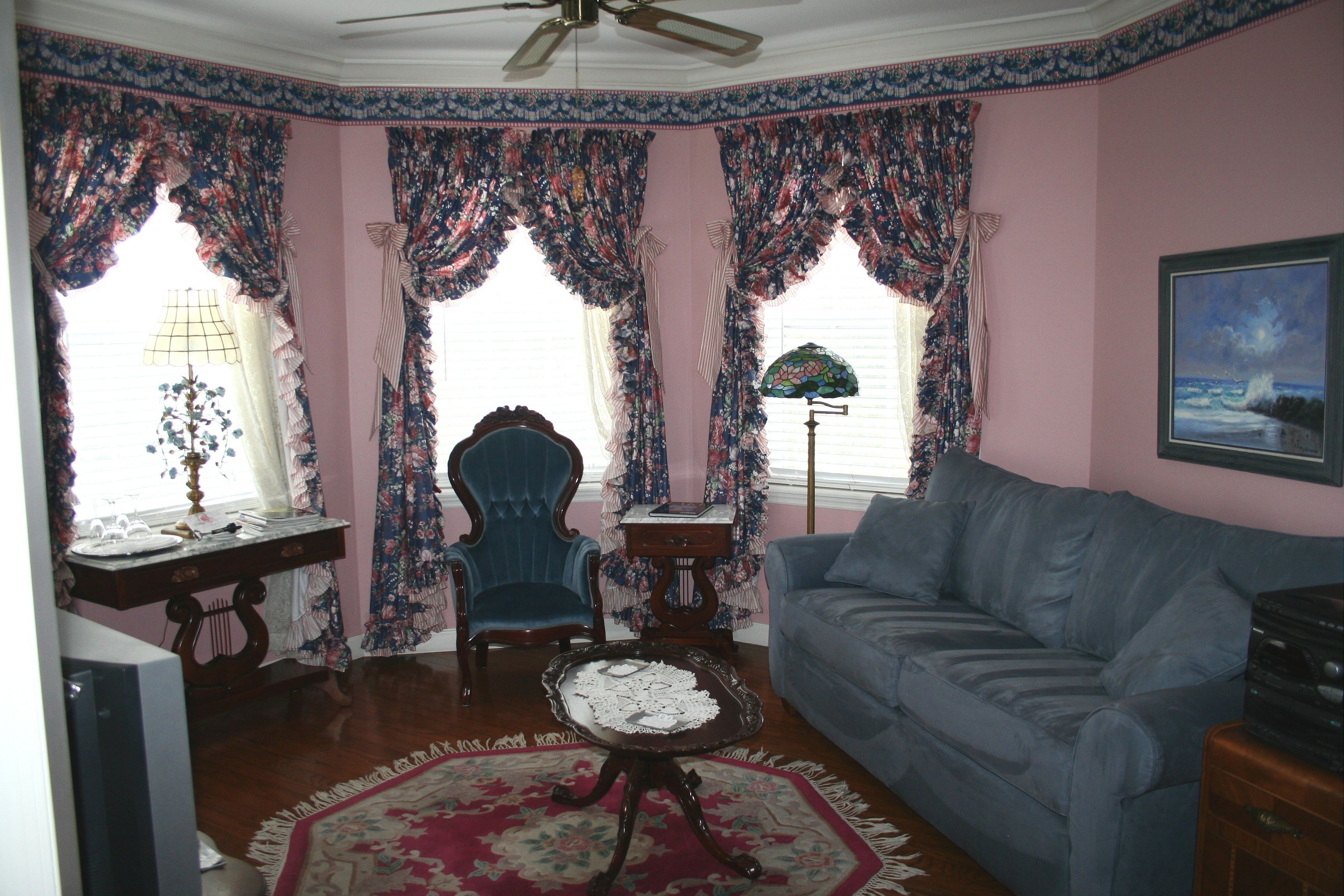 A living room with a blue sofa, a wooden coffee table, a blue armchair, and a patterned rug.