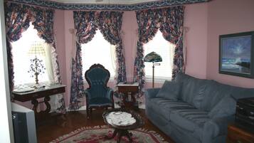 A living room with a blue sofa, a wooden coffee table, a blue armchair, and a patterned rug.