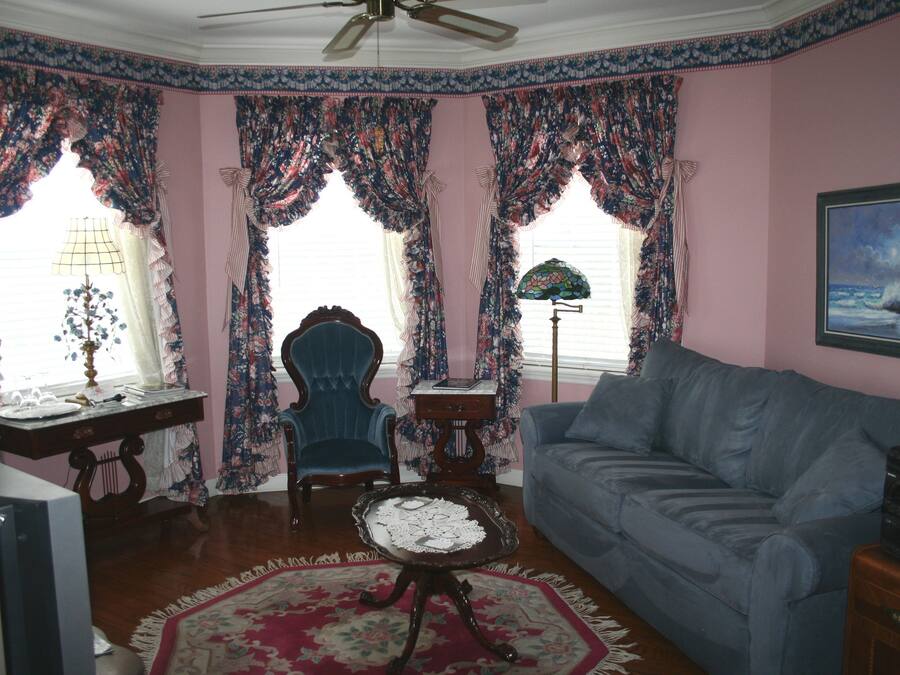 A living room with a blue sofa, a wooden coffee table, a blue armchair, and a patterned rug.