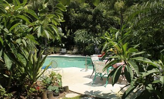 Una piscina al aire libre, sillones reclinables de piscina