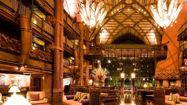 A spacious lobby with high ceilings, wooden architecture, and multiple seating areas.