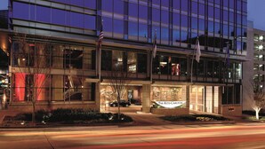 A modern hotel with a glass facade, a visible entrance, and flags. - The Ritz-Carlton, Charlotte (Charlotte)