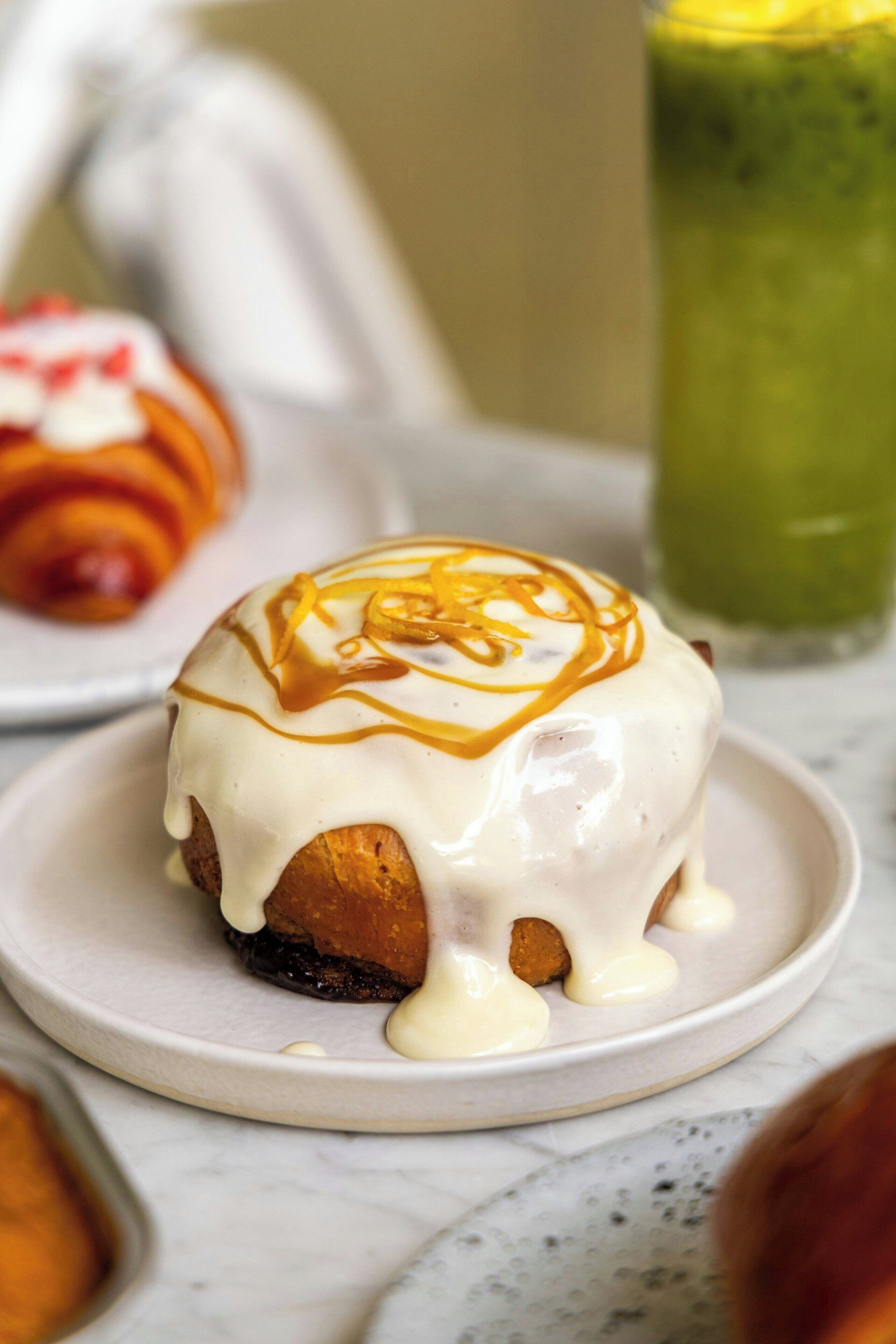 En dessert på en tallrik, garnerad med karamellsås och rivet citronskal.