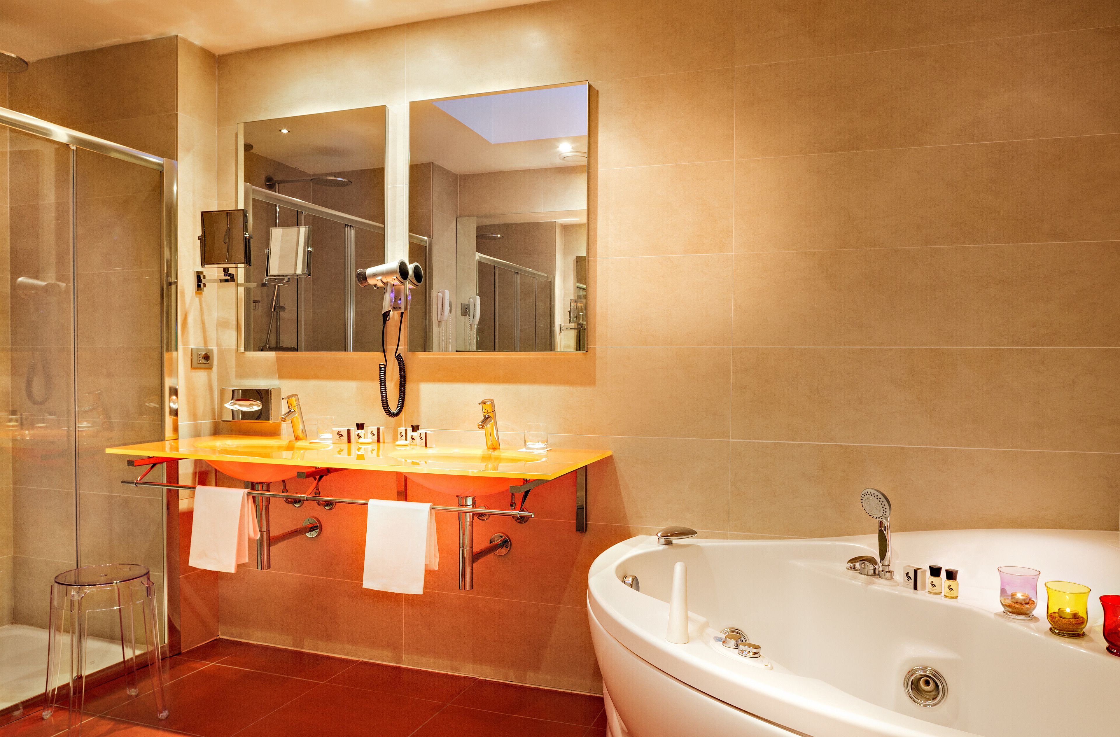 Een moderne badkamer met een douchecabine van glas, een wastafelmeubel met dubbele wastafel en een vrijstaand bad.