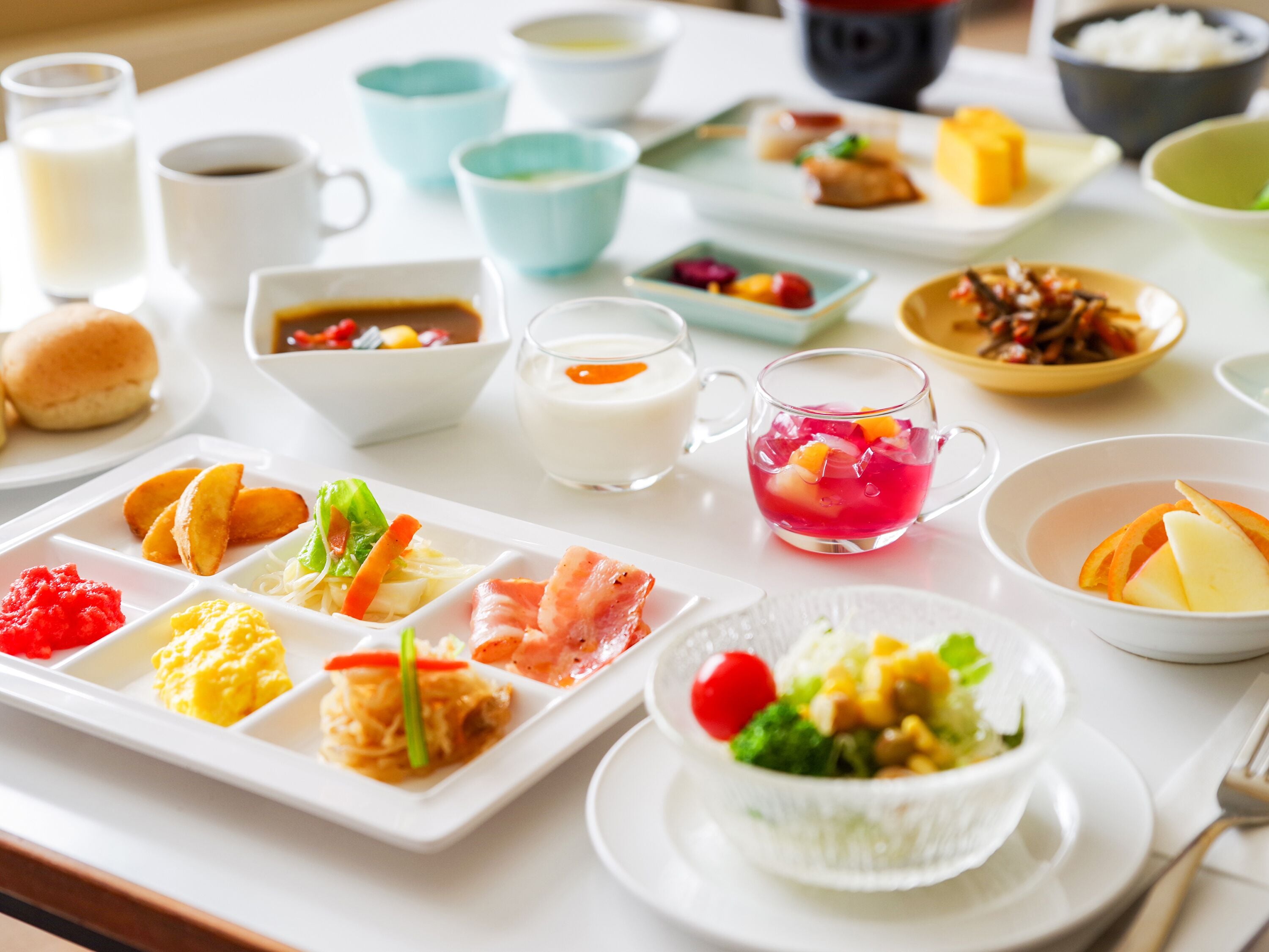 Una variedad de platos y bebidas sobre una mesa, como sushi, arroz y una bebida con fruta.