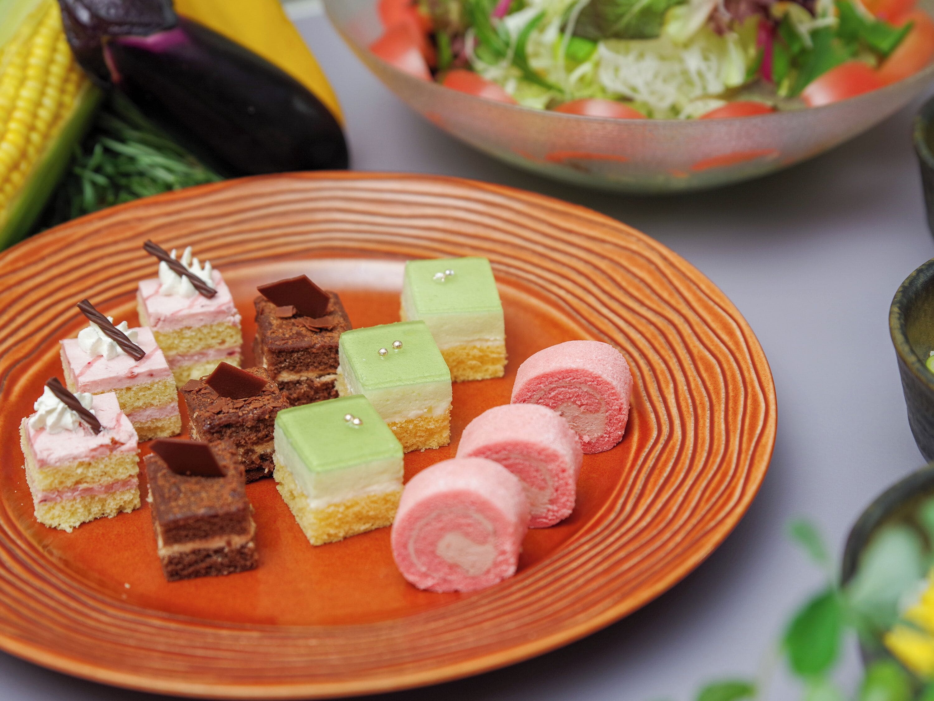 Une assiette remplie d’une variété de desserts, présentée sur une assiette dont le bord est orange.
