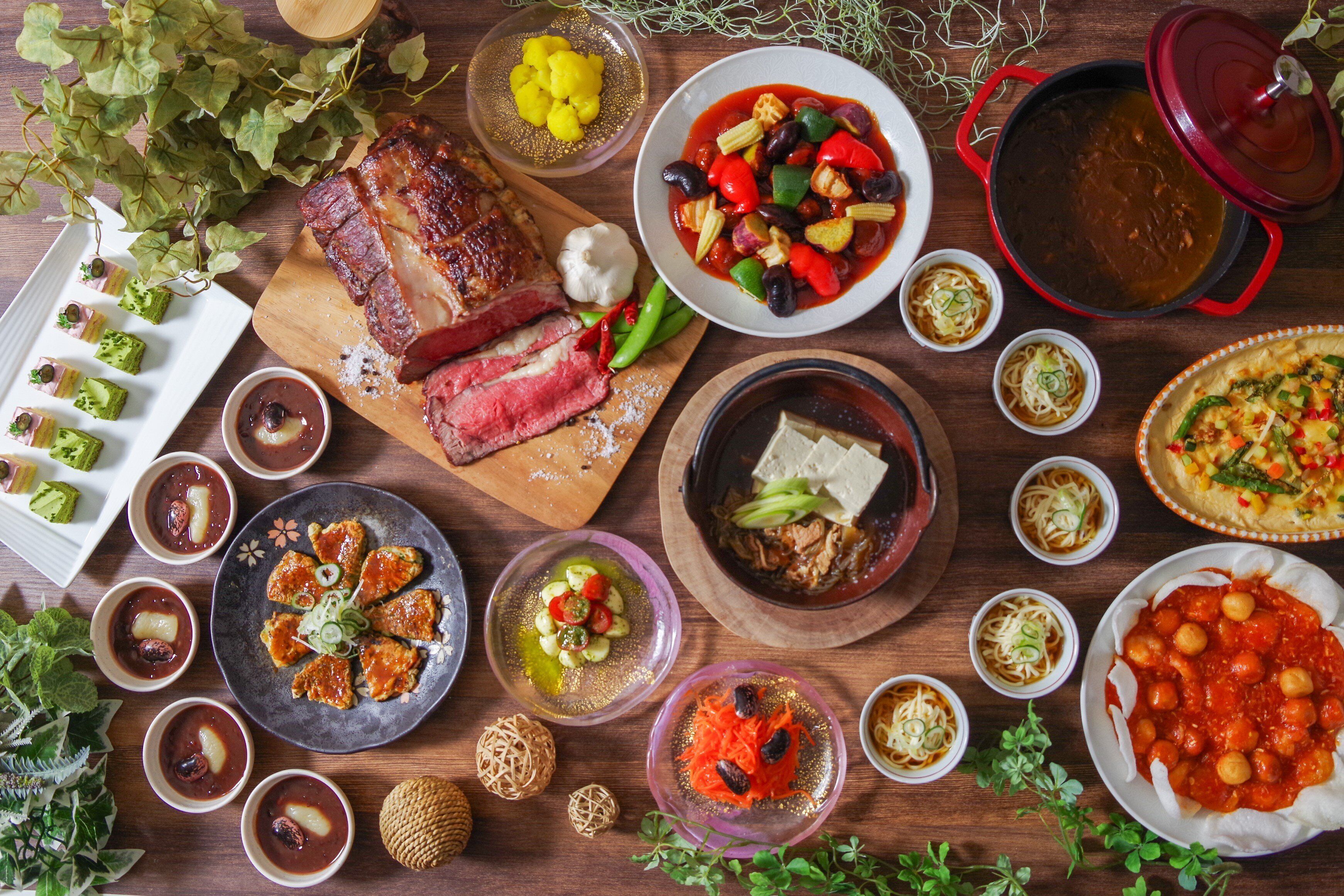 A variety of dishes including a roasted duck, a bowl of soup, and several small plates of food.
