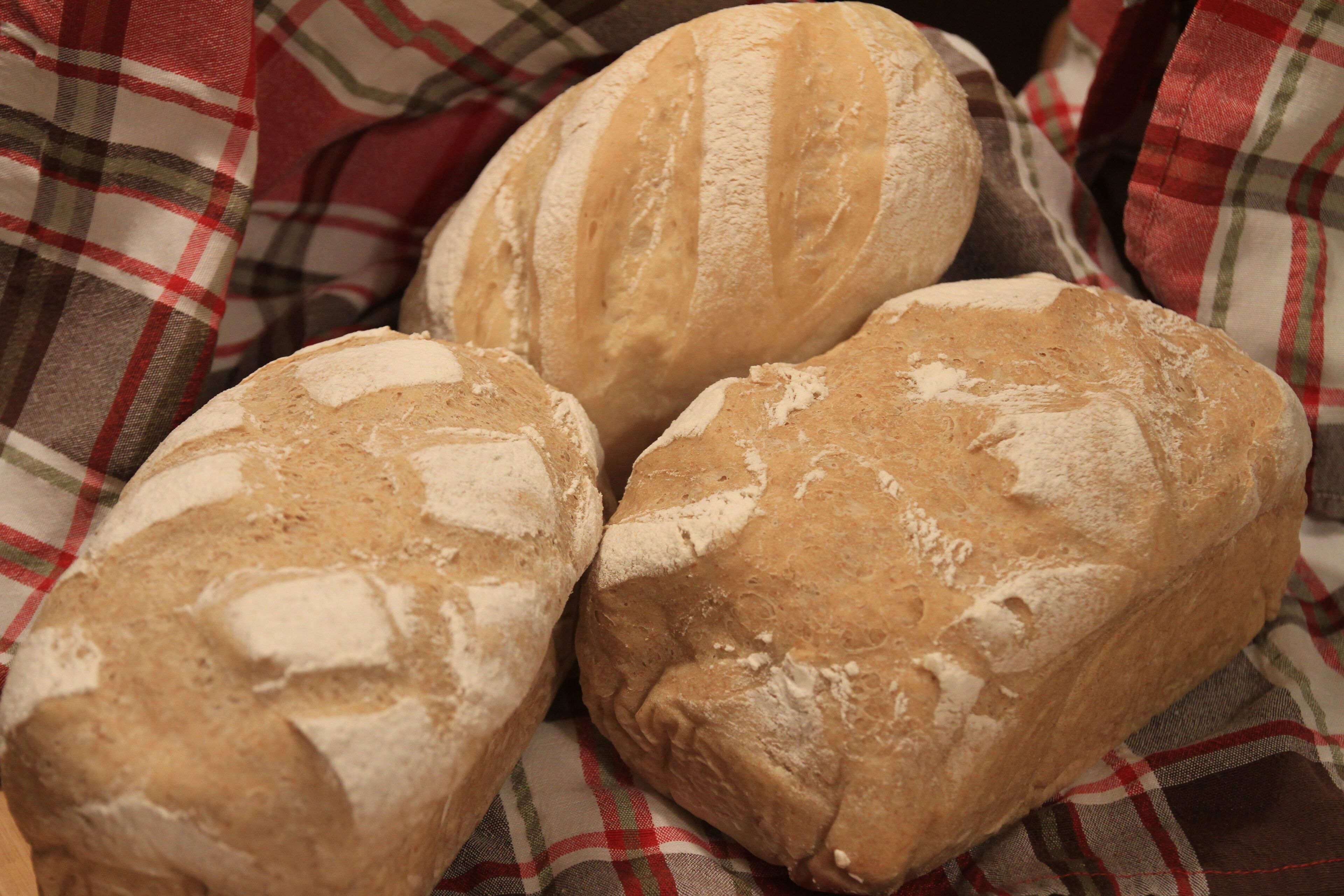 Three loaves of bread on a checkered cloth.