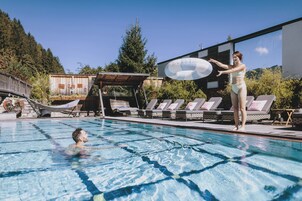 Una piscina cubierta, una piscina al aire libre, sombrillas, tumbonas