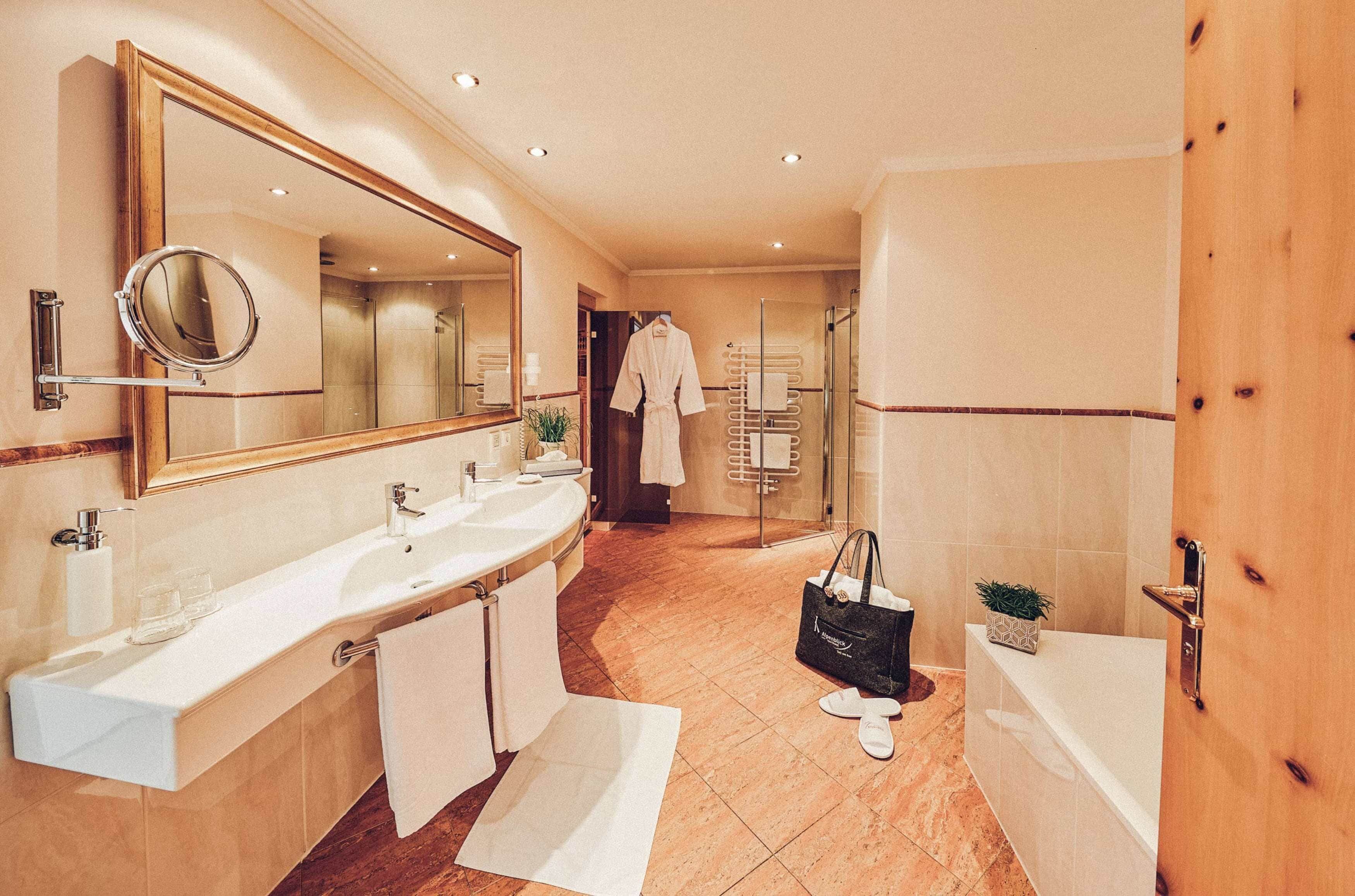 Un baño moderno con lavamanos doble, un espejo grande, bañera y cabina de ducha.