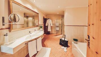 Un baño moderno con lavamanos doble, un espejo grande, bañera y cabina de ducha.