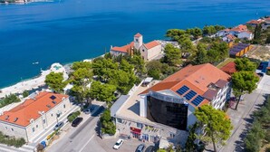 Un hotel costero con un edificio destacado que cuenta con paneles solares, una zona de playa y vistas al mar.