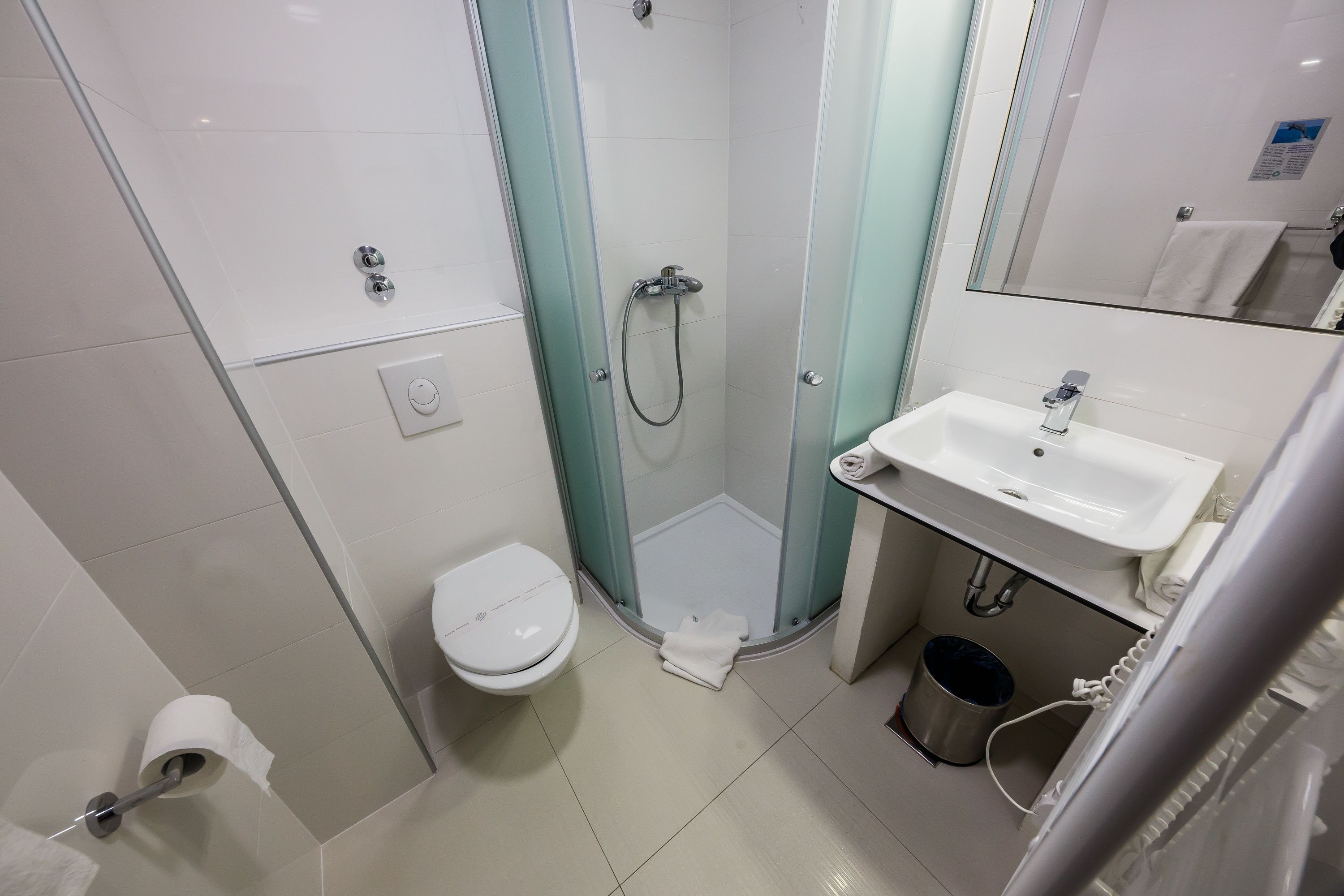 Un baño pequeño con inodoro, ducha y lavamanos.