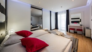 Una habitación de hotel moderna con una cama grande, un escritorio y un espejo.