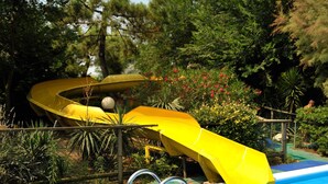 A swimming pool with two yellow slides and a blue poolside area. - Hotel Valdor (Cavallino-Treporti)