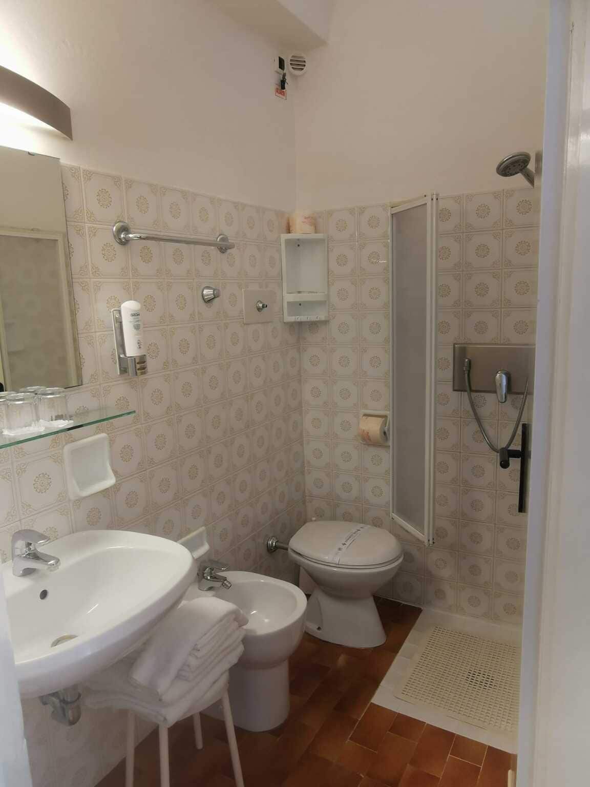 A bathroom with a sink, toilet, and shower.