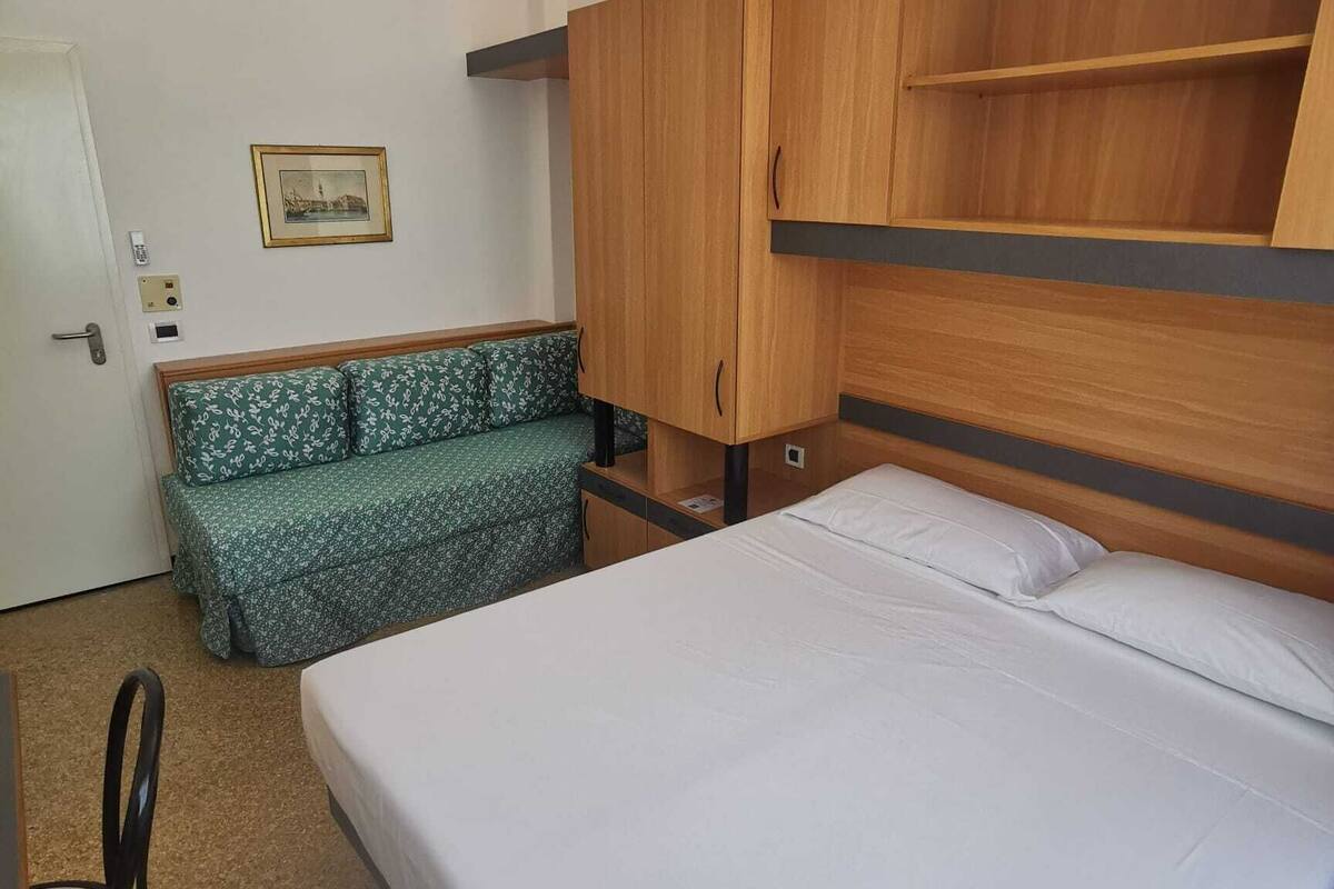 A room with a bed, a bench, and a wardrobe.