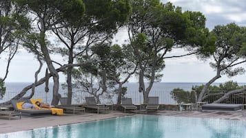 En säsongsöppen utomhuspool, parasoller och solstolar