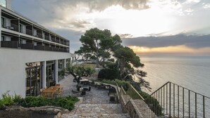 Un edificio moderno con una escalera de piedra que conduce a una terraza con vistas al mar.