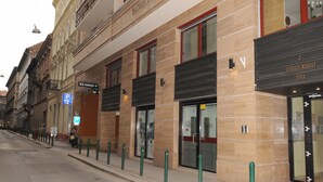 Un edificio con un cartel que dice 'SZEKELY MIRALY UTCA' y una señal de estacionamiento.