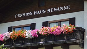 A building with a sign reading "Pension Haus Susanne" and a balcony with colorful flower boxes. - Haus Susanne (Radstadt)