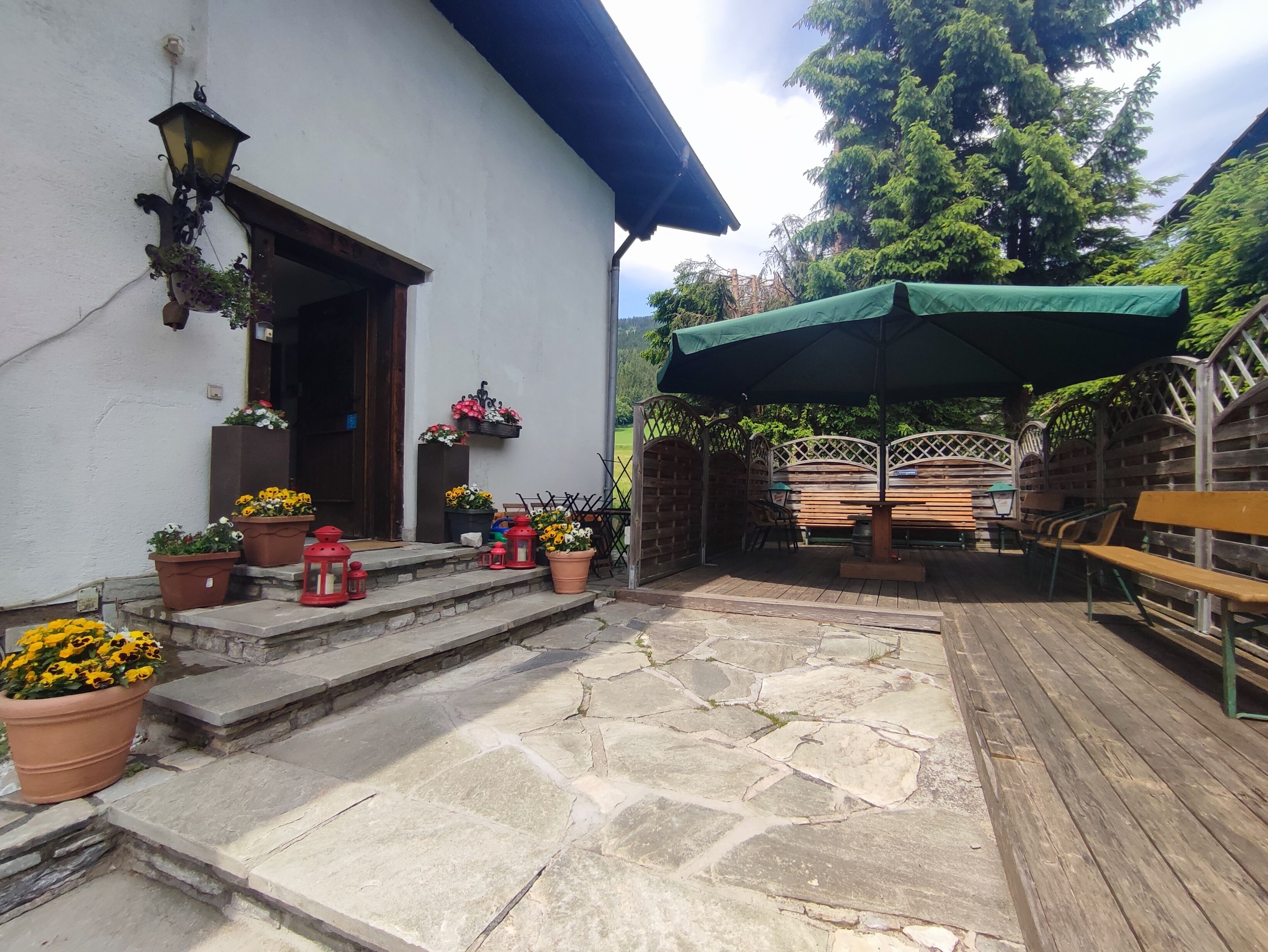 Un patio con suelo de piedra, mobiliario exterior y plantas en macetas.