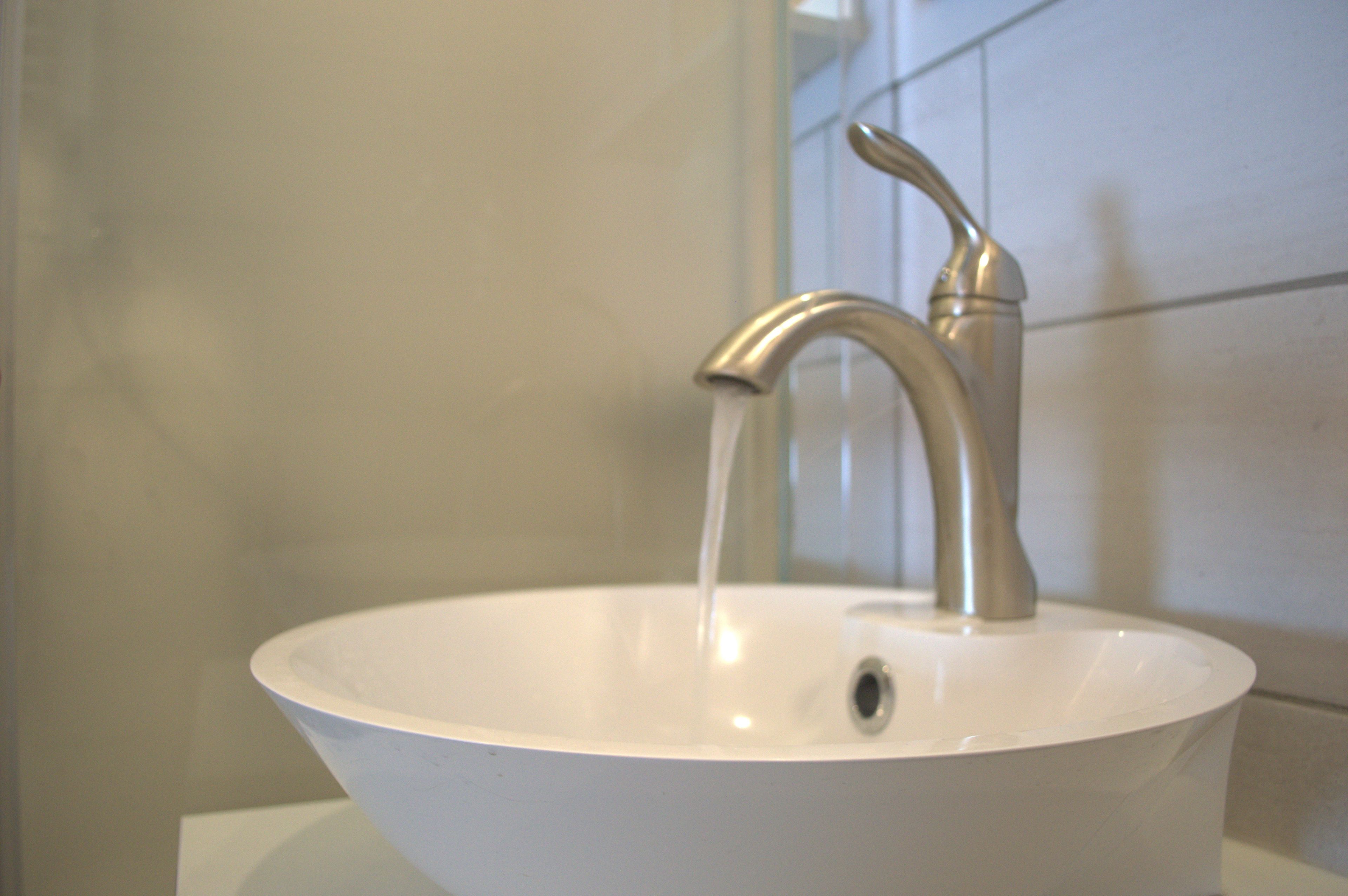 A bathroom sink with a modern faucet and a single drain.