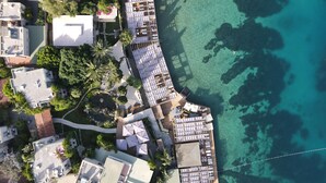 An aerial view of a coastal resort with multiple buildings, a dock, and clear turquoise waters. - No 81 Hotel (Bodrum)