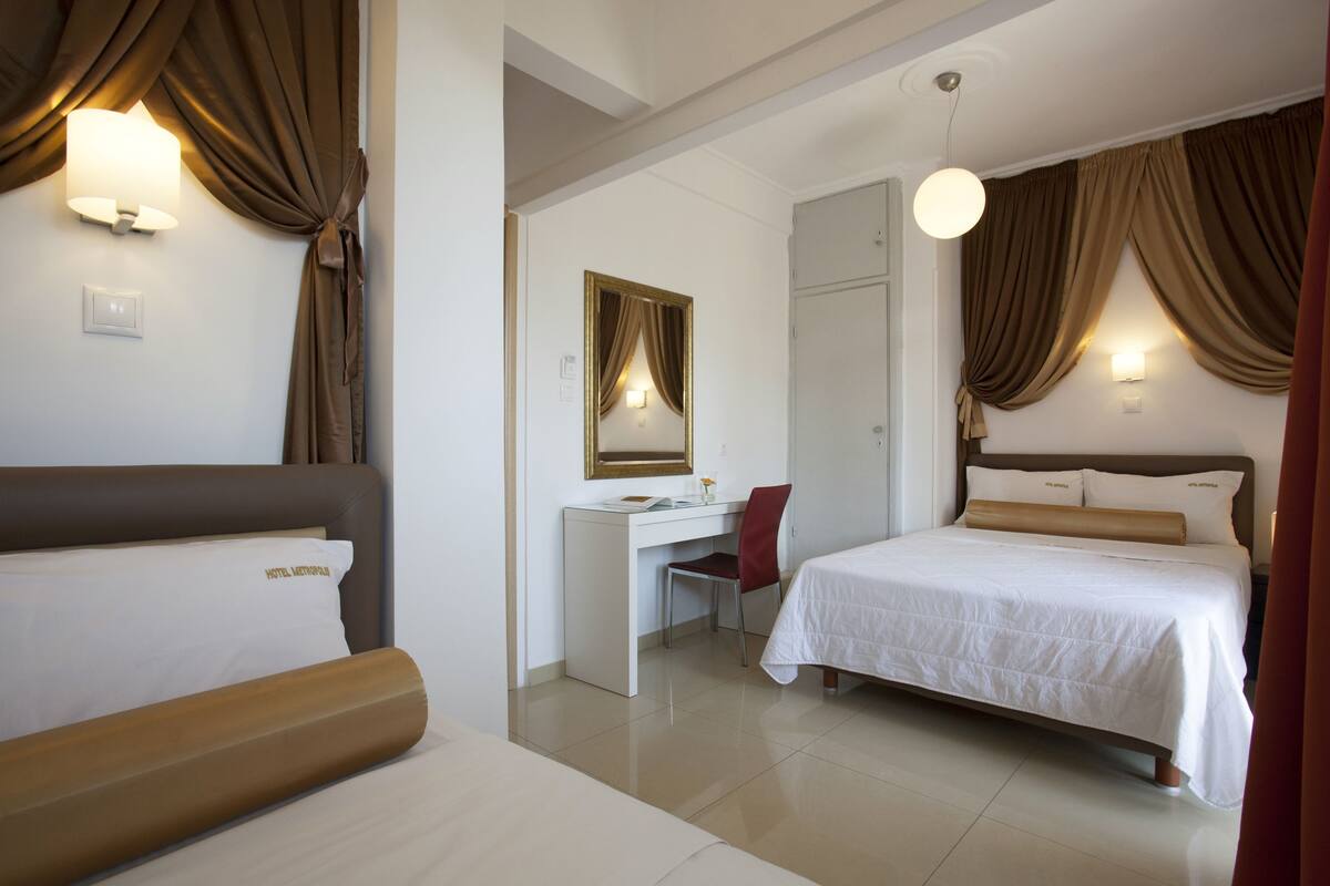 A hotel room with a bed, desk, and chair.