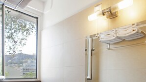 A bathroom with a white sink, a mirror, and a towel rack. - Metropolis Hotel (Athens)