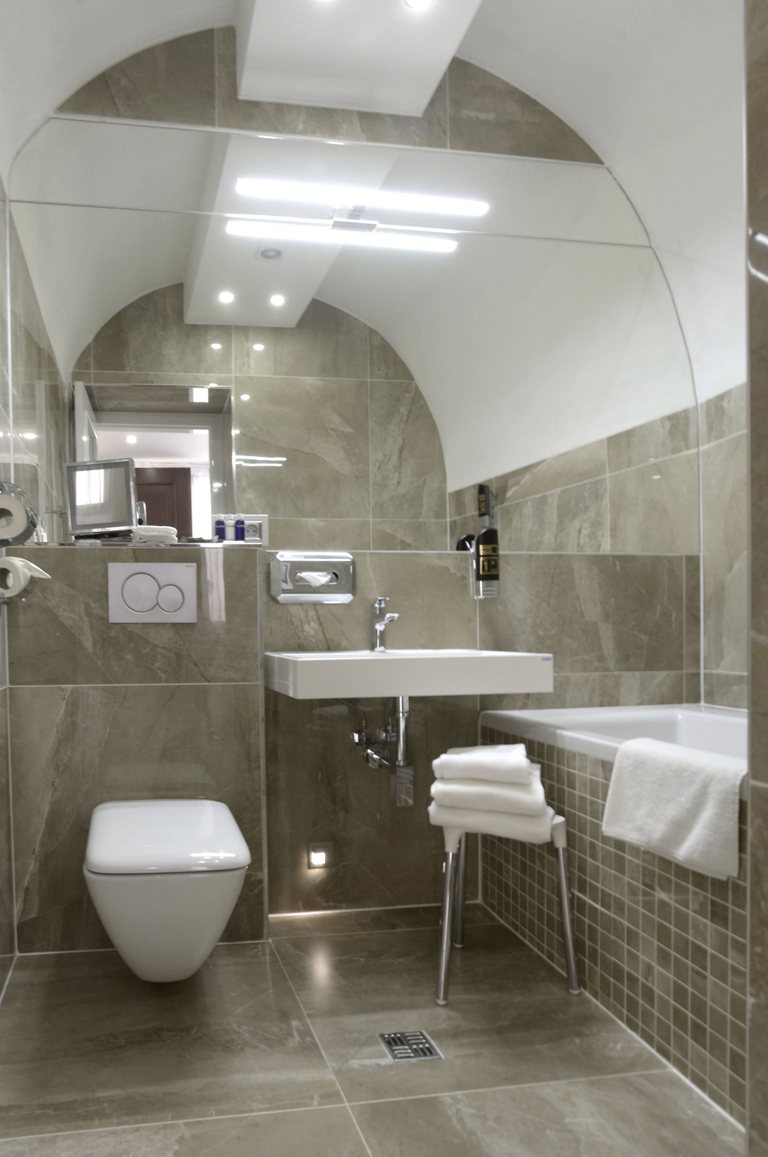 A modern bathroom with a toilet, sink, and bathtub.