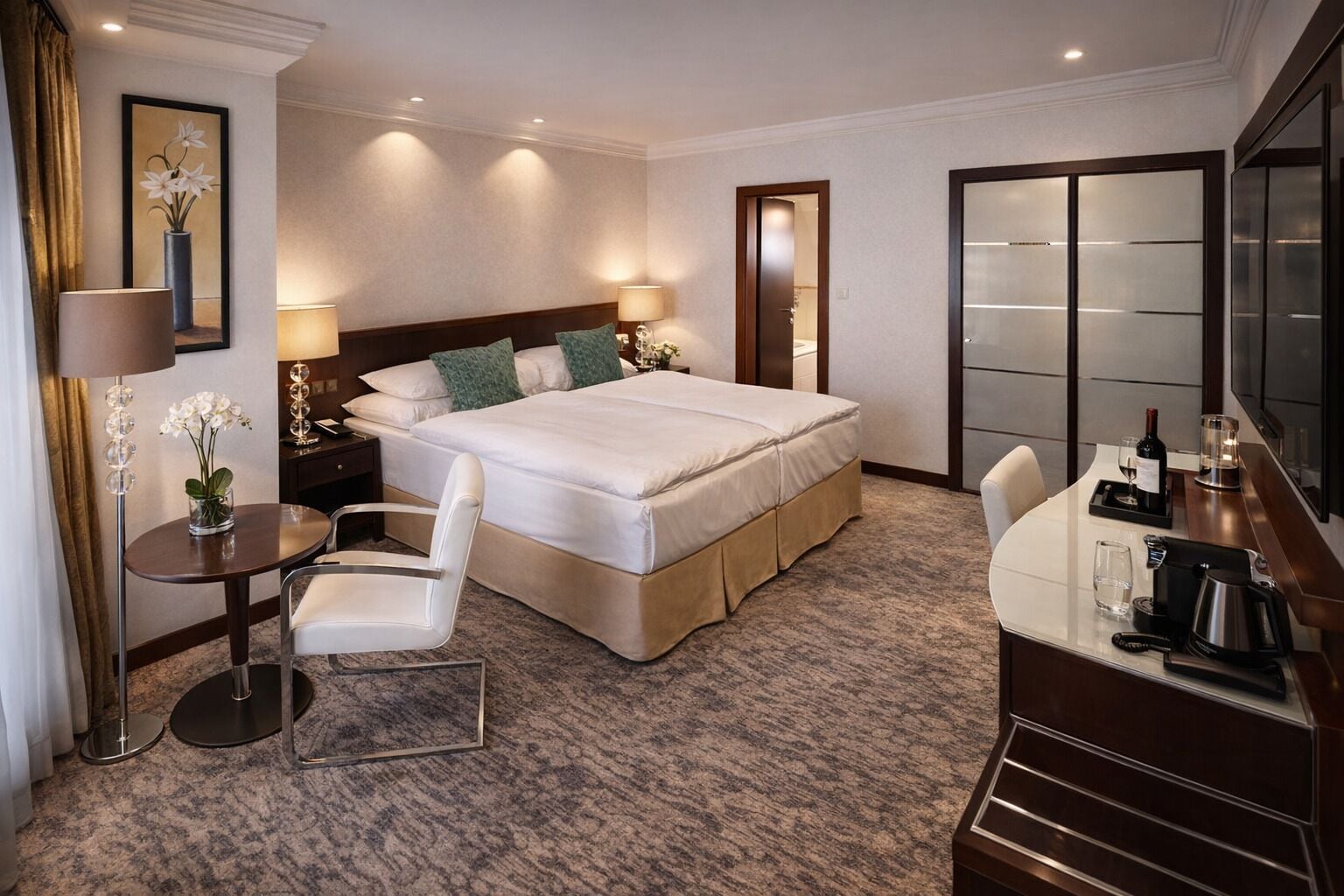 A hotel room with a large bed, a desk with a chair, a vanity with a mirror, and a television.