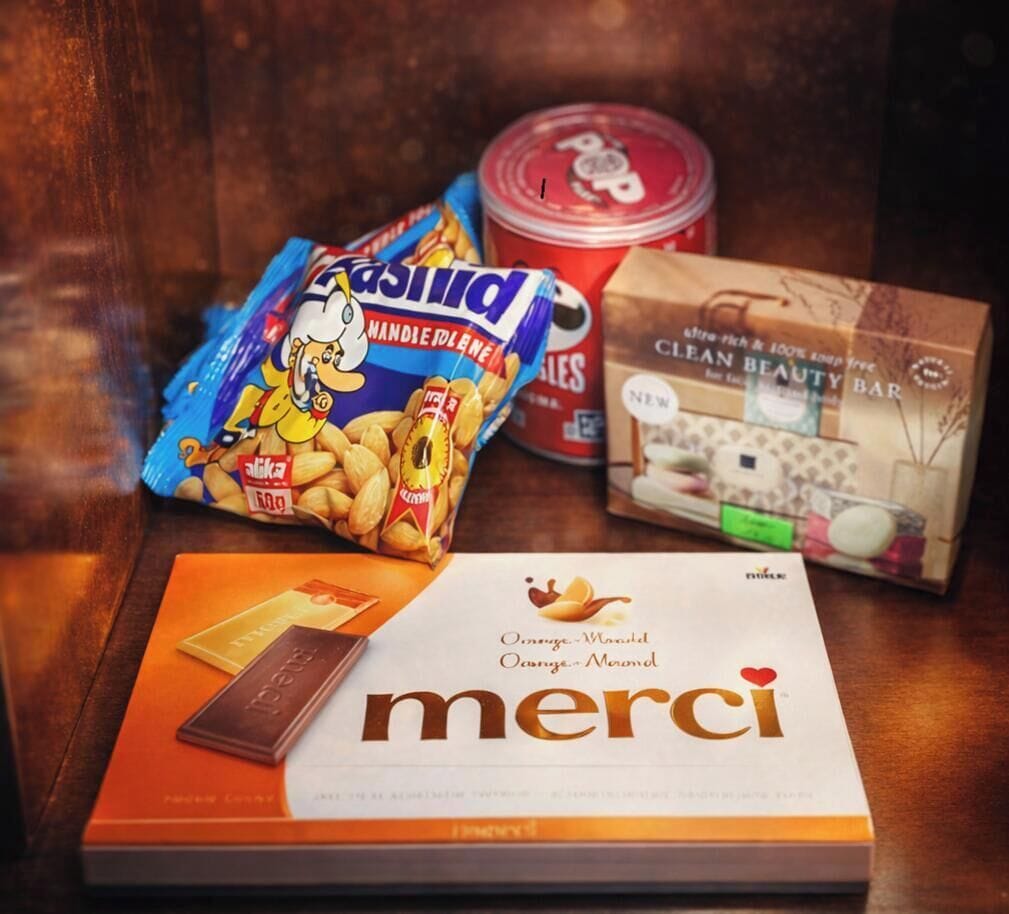 A box of orange marmalade, a bag of almonds, a container of cream, and a bar of chocolate.